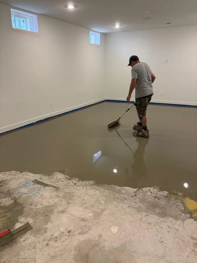 Self leveling compound being spread over a concrete slab before installation