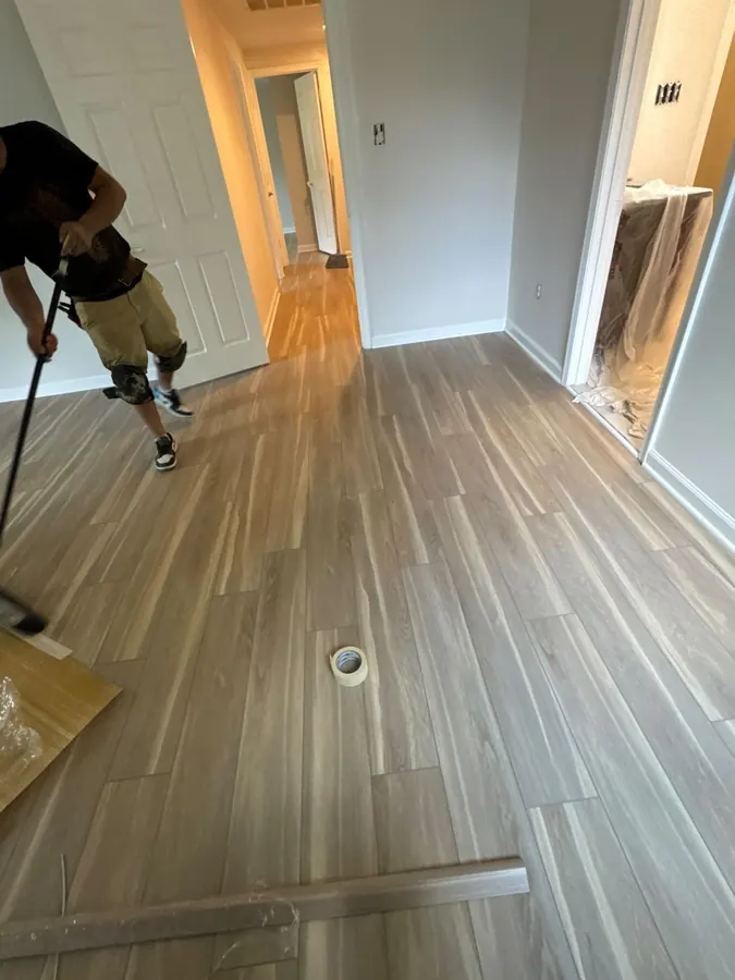 Greige toned LVP finished through a bedroom with the floor vent cut in