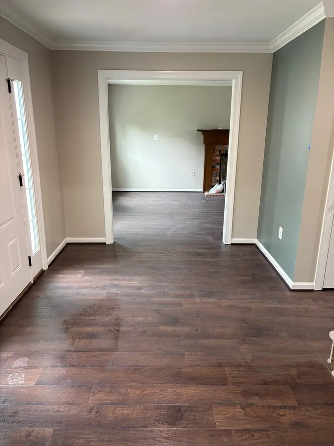 Dark LVP running from an entry through to the next room