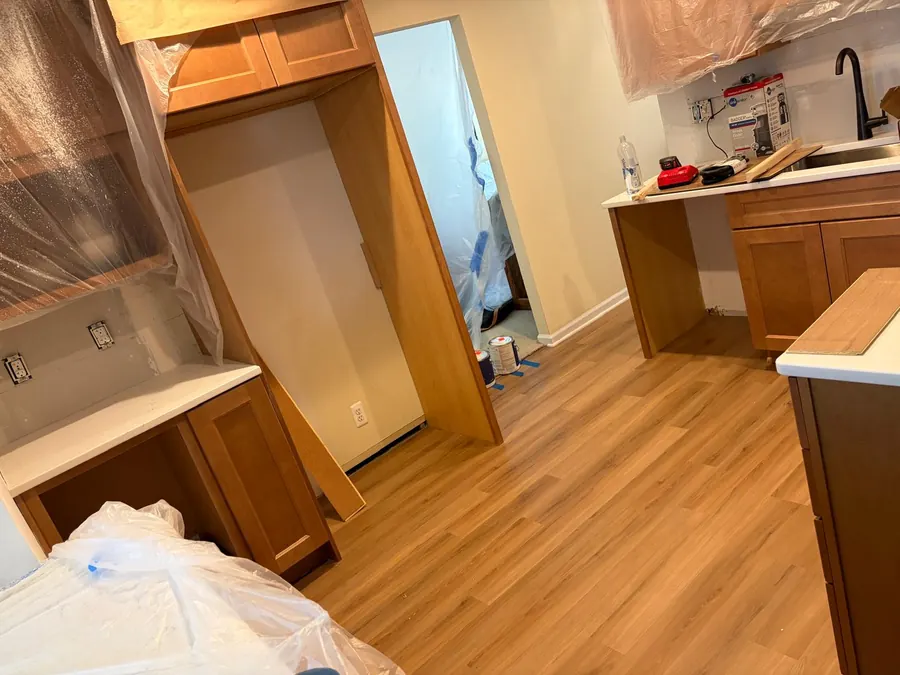 Light oak toned LVP fitted around kitchen cabinets