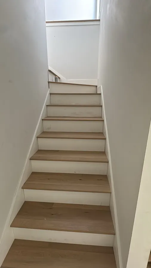 Pale white oak treads and white risers up a straight flight