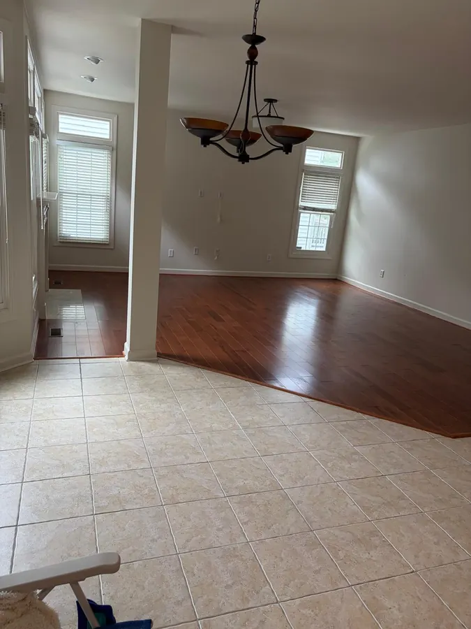 Red toned hardwood meeting tile at a dining room threshold