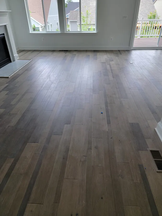 Driftwood toned hardwood across a great room with a wall of windows