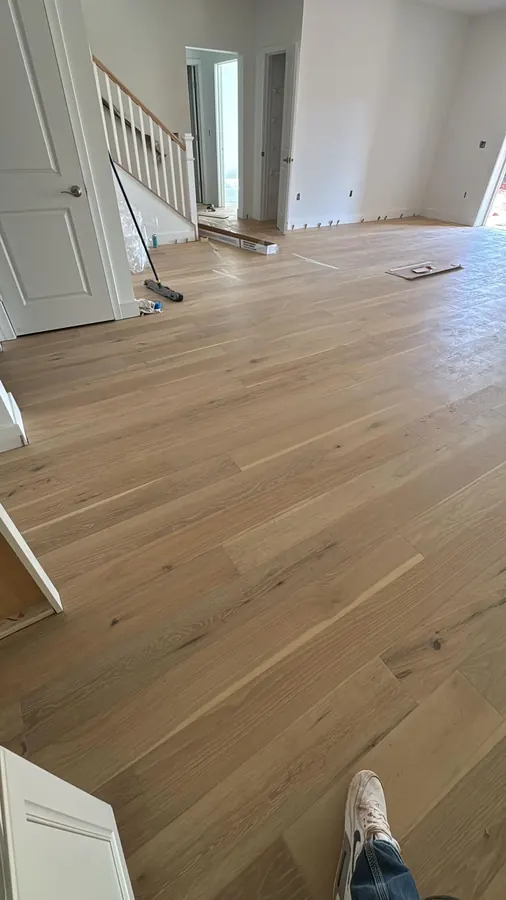 White oak planks running the length of an open plan room towards the stairs